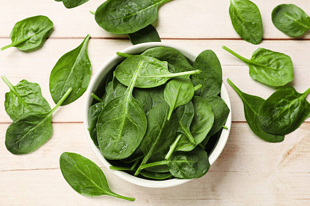 istock Fresh spinach leaves on light wooden table, top view 2247075486