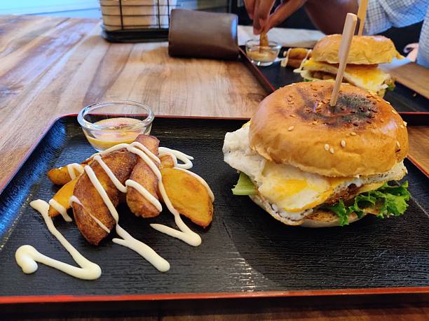 A cheese burger served on a plate, featuring a toasted bun, fresh vegetables, and melted cheese for a tasty and visually appealing presentation.