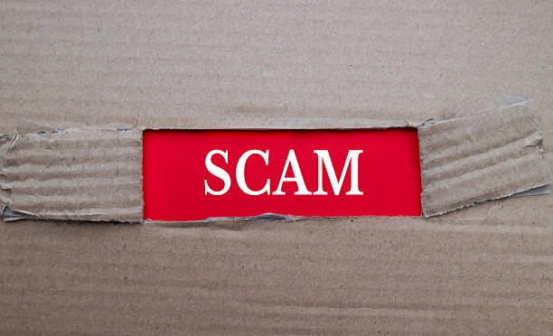 istock Scam text on red paper over torn card box background 2247080230