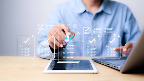 istock Businessman using digital checklist interface on tablet and laptop. Concept of online document verification, approval workflow, electronic forms, task management, and digitalization. 2247080859