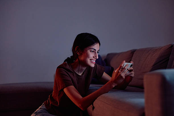 istock Woman enjoying mobile gaming alone at night 2247081073