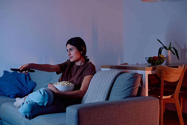 istock Woman relaxing on sofa watching TV at night 2247081198