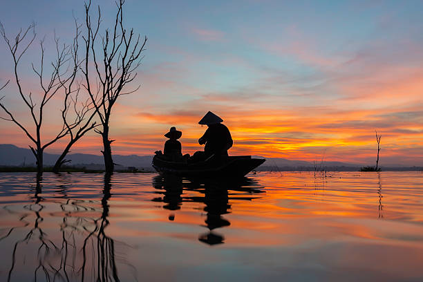 Vietnamese man catching fishes in Thu Bon River near Hoi An, central Vietnam. Hoi An is situated on the east coast of Vietnam. Its old town is a UNESCO World Heritage Site because of its historical buildings.