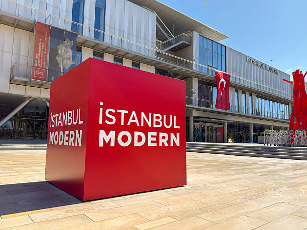 Istanbul, Turkey - August 28, 2025: Red Istanbul Modern cube sign and museum facade with Turkish flag on display