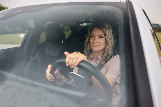 istock Smiling woman enjoying while driving a car. 2247083729