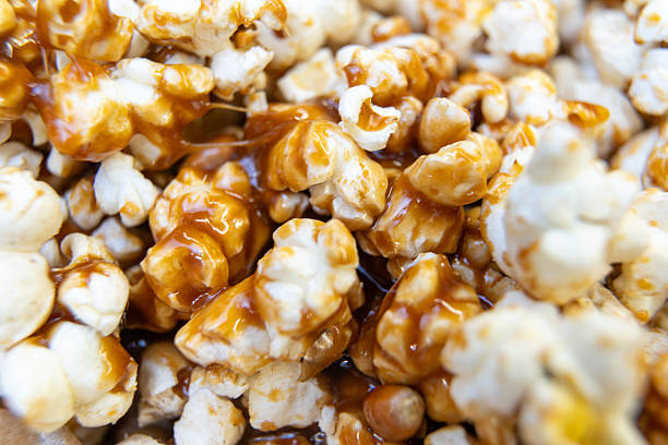 A tight shot of golden caramel popcorn, freshly made at home. The warm tones and glistening caramel make it look delicious and inviting. Perfect for food blogs or recipe imagery.
