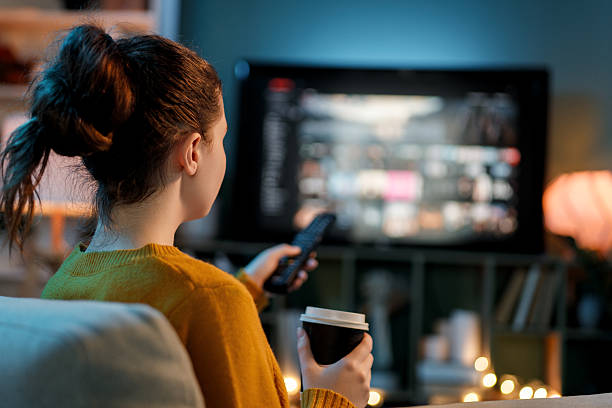 istock woman watching TV at home 2247084111