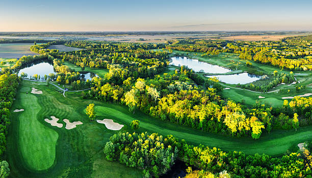 istock Golf course panorama at dramatic sunrise with green fairways and forest 2247084942