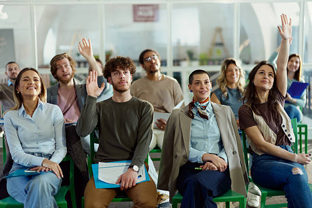 istock Happy creative colleagues raising hands on a seminar in board room. 2247086492