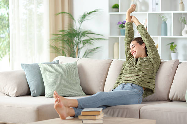 istock Happy woman stretching arms after napping on a couch 2247087115