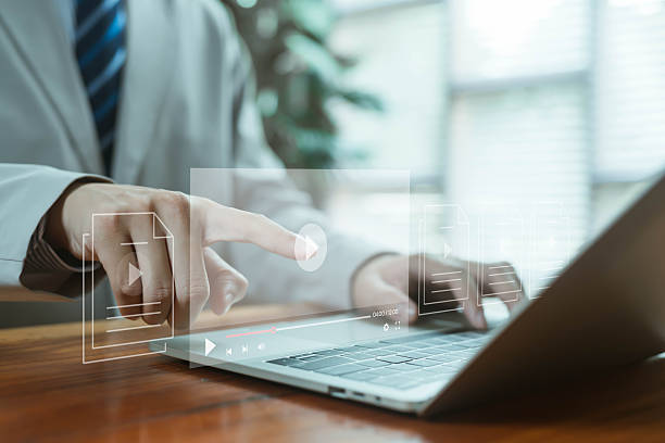 istock A futuristic digital video interface displayed above a laptop as a hand taps the play icon, symbolizing online media creation, streaming technology, file management, and modern content production 2247087204