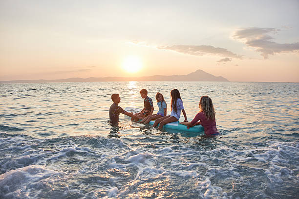 istock Family enjoying water activity together at sunset 2247088476