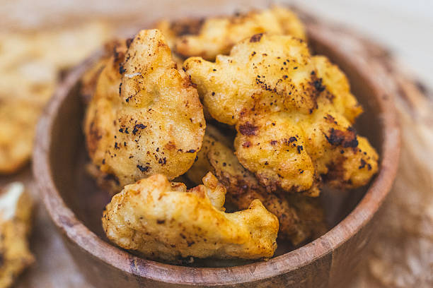 Close-up of homemade chicken nuggets on a plate, golden and crispy. Captured in a cozy kitchen setting, ideal for recipe blogs, menus, and stock photography websites.