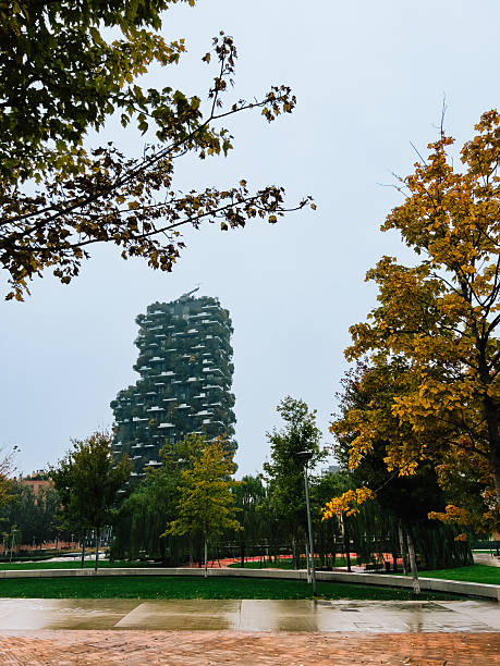 Bosco Verticale, showcasing sustainable architecture and vibrant greenery, enhances Milan cityscape against backdrop of cloudy autumn day, blending nature with urban living. Vertical forest towers