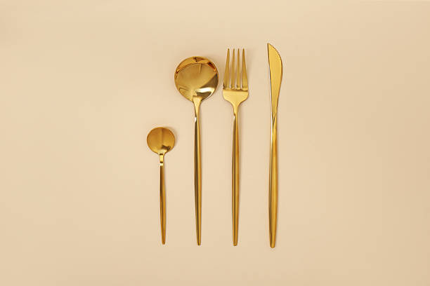 istock Stylish golden cutlery set on beige background, flat lay 2247090431