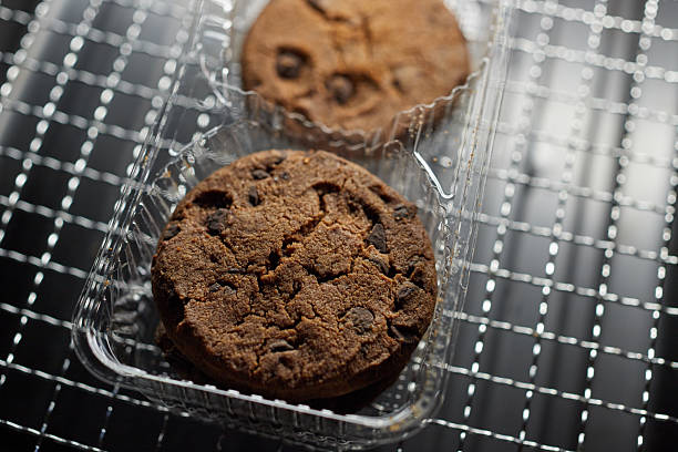 Industrial and processed chocolate chips cookies in a plastic package isolated on white background. Sweet unhealthy food or dessert