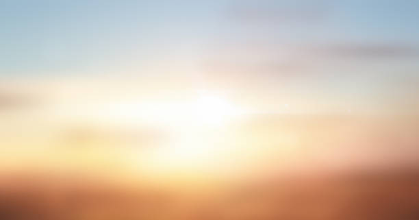 A soft, dreamy golden sunrise glowing over a blurred horizon with warm orange, yellow, and pastel tones blending into a gentle blue morning sky. Atmospheric, abstract natural background ideal for wellness, meditation, calm mood concepts, peaceful landscapes, inspirational themes, nature backdrops, and minimalist designs. Warm sunlight flare and smooth gradient create a soothing, tranquil, cinematic aesthetic perfect for banners, ads, presentations, and modern digital visuals.