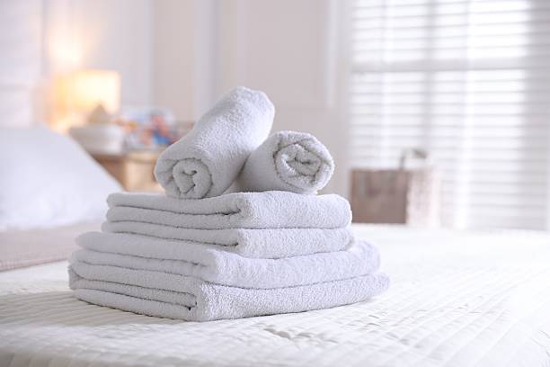 istock Stack of clean towels on bed linens at home, closeup 2247093314