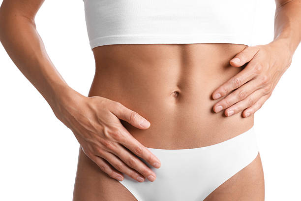 istock Woman with flat belly on white background, closeup 2247094124