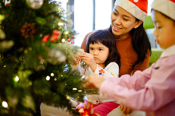 istock Family Decorating Christmas Tree Together at Home 2247097017