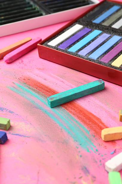 istock Many colorful chalk pastels on pink background, closeup 2247097023