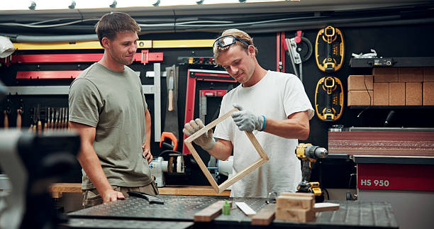 istock Business, woodwork and men with tools, feedback and equipment with cooperation. People, employees and mentor with frame, industry and material with project, coaching and building timber production 2247097218