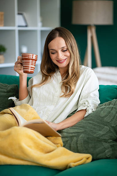 istock Woman relaxing at home reading a book enjoying coffee 2247097428