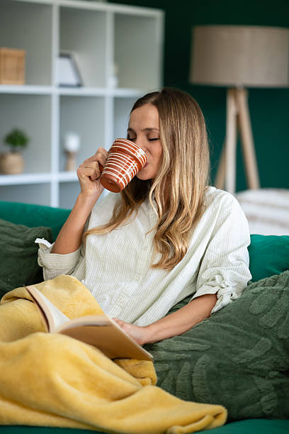 istock Woman relaxing at home drinking coffee and reading 2247097458