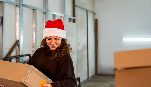 istock Cheerful woman wearing Santa hat working at warehouse 2247098045