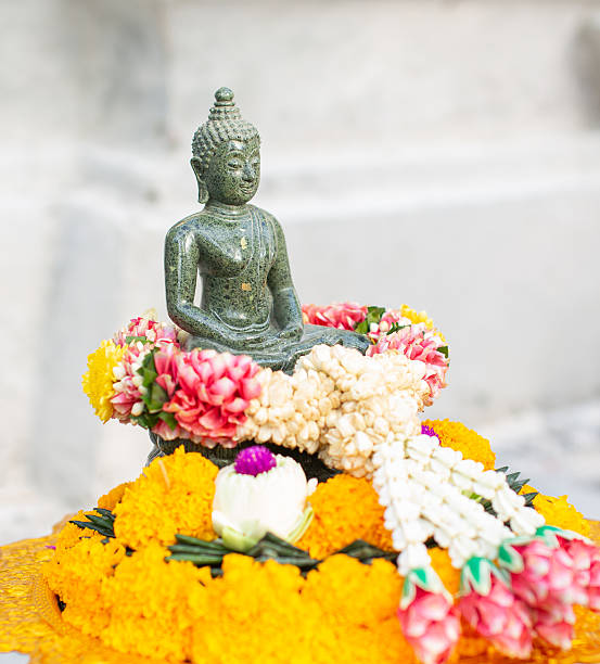 istock Buddha statue in meditation posture surrounded by flowers 2247098269