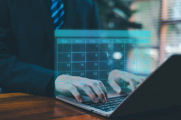 istock Businessman typing on a laptop with a glowing digital calendar interface floating above the keyboard, representing scheduling, planning, time management, online appointments, task organization. 2247098576