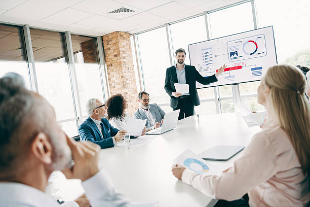 istock Professional teamwork and collaboration in a corporate meeting with a leader presenting on a large office screen 2247099878