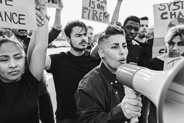istock Multigenerational people protest against climate change - Crowd doing demonstration for stopping pollution - Green and environment concept - Focus on megaphone - Black and white editing 2247101020