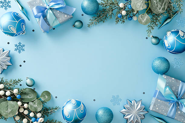 istock Christmas frame with blue ornaments, gift boxes, fir branches on light blue background. Flat lay, top view, copy space 2247102981
