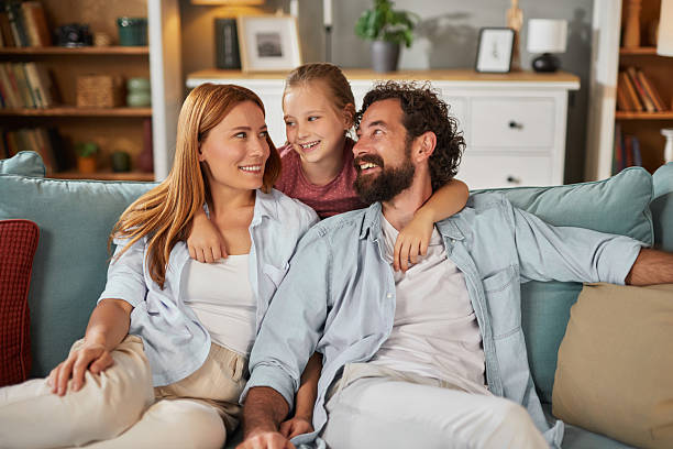 istock Happy family relaxing together on sofa at home 2247102984
