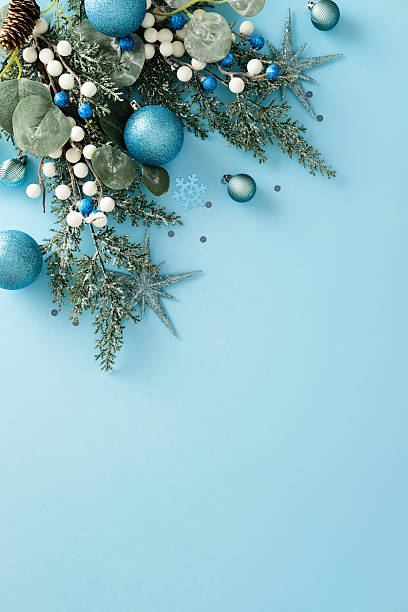 istock Christmas top corner border: fir branches with blue and white ornaments on light blue background. 2247103203