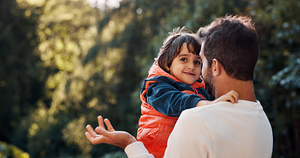 istock Nature, support and dad hugging child for bonding, connection or adventure together in park. Smile, love and father embracing boy kid outdoor with care, family and happiness in summer with fun. 2247103662