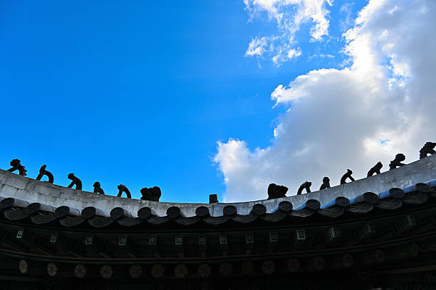 Old painted wooden ceiling in bright colors with lotus flowers at the Changdeokgung Palace in Seoul, South Korea..