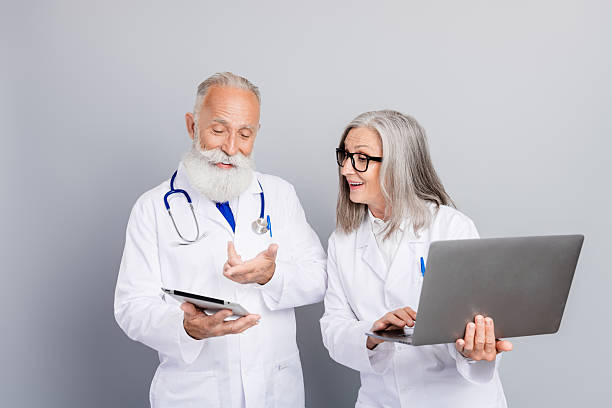 istock Two experienced doctors discuss patient care with tablet and laptop in white coats in a clinical friendly moment 2247107186