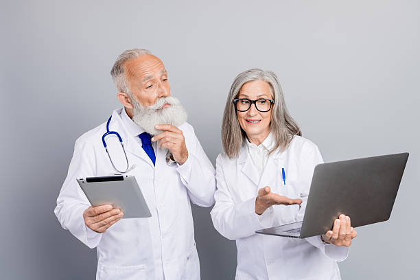 istock Senior doctors discuss patient care using tablet and laptop in a clinic setting to illustrate expertise and teamwork 2247107213