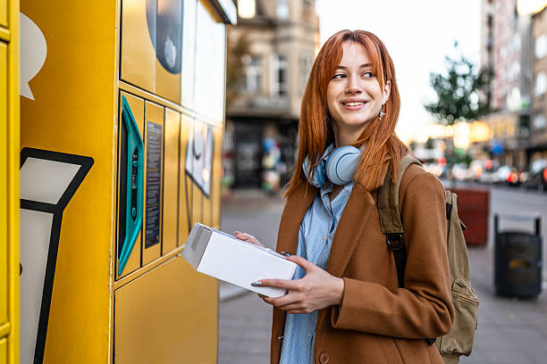istock Young woman collecting package from outdoor parcel locker 2247109182