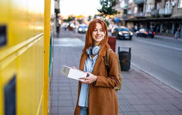istock Young woman collecting package from parcel locker 2247109201