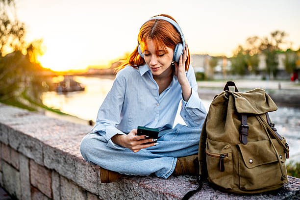 istock Young woman enjoying music outdoors during sunset 2247109333