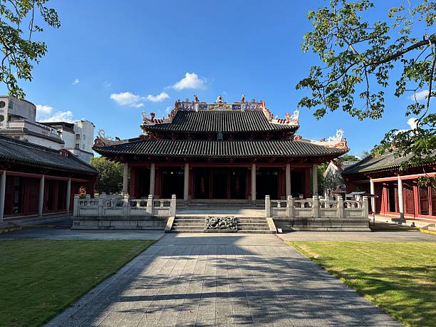 istock Traditional Chinese-style temple with tiled roof and stone pathway under clear blue sky 2247111116