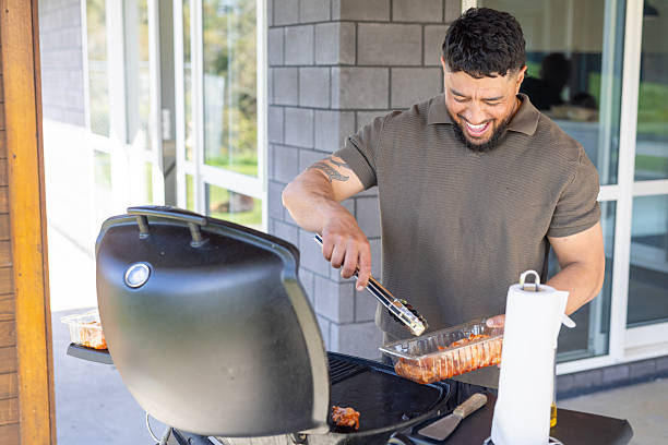 Maori man cooking a BBQ at home outdoors