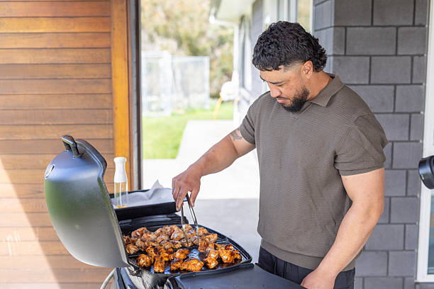 istock Maori man cooking a BBQ at home 2247111368