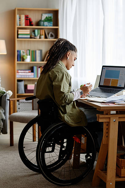 istock Young Adult Woman with Disability Reviewing Documents at Home Workspace 2247112332