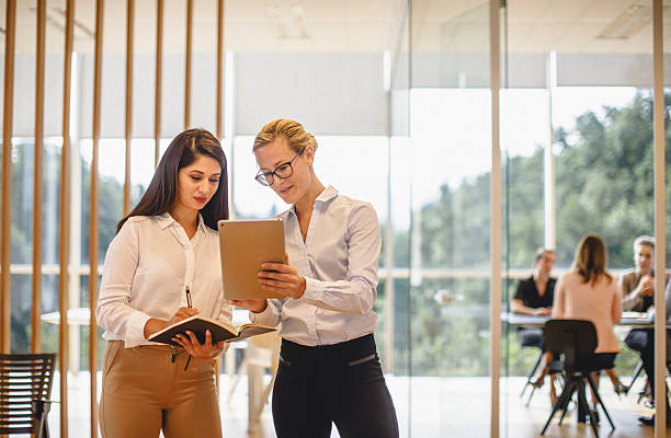 istock Caucasian Businesswomen Collaborating in Stylish Office Using Digital Tablet with Engaged Focus 2247112937