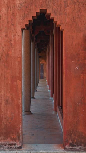 istock Long corridor with red walls and arched columns in a historic building 2247113625