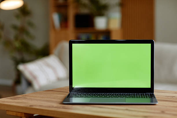 istock Modern Laptop with Green Screen Displaying on Wooden Table in Home Interior 2247115391